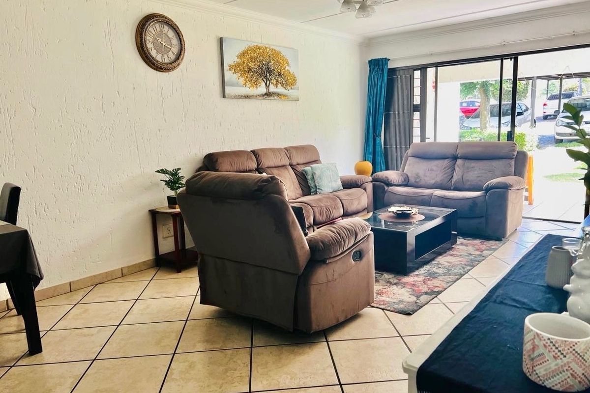 A living room featuring tiled flooring and a large sliding glass door providing access to the exterior.