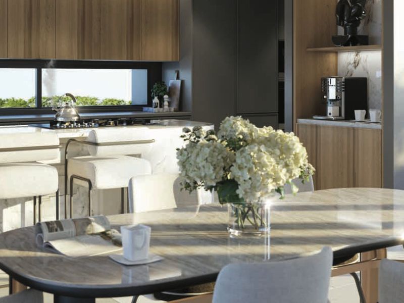 Modern open-plan kitchen and dining area featuring high-end cabinetry, stone countertops, and integrated appliances, creating a seamless and sophisticated living space.