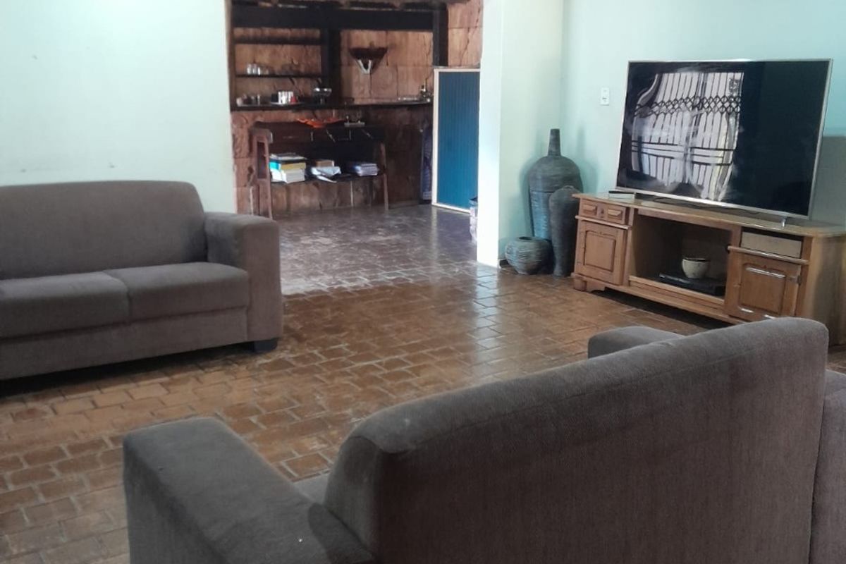 Spacious living room featuring terracotta tile flooring, recessed downlighting, and a coved ceiling, with an open transition to an adjacent secondary area.
