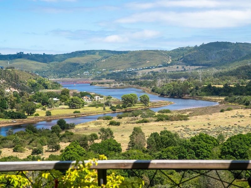 Scenic elevated view overlooking a winding river, lush green valley, and distant rolling hills.