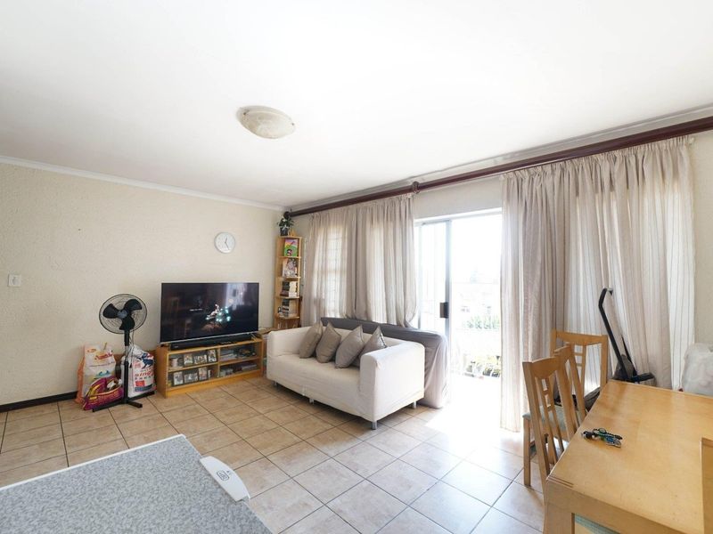 Open-plan living and dining area featuring tiled flooring and a large sliding glass door providing access to the outdoor space.