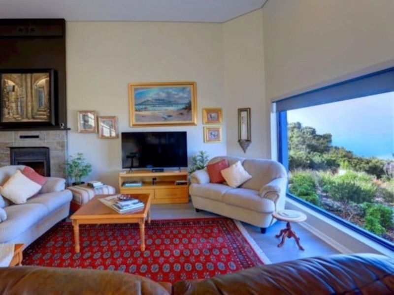 Spacious living room featuring a fireplace and a large picture window offering scenic outdoor views, creating a bright and inviting atmosphere.
