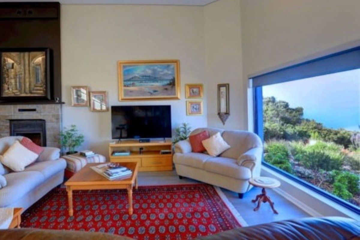 Spacious living room featuring a fireplace and a large picture window offering scenic outdoor views, creating a bright and inviting atmosphere.