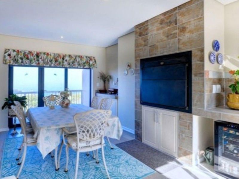 Living area featuring a tiled fireplace surround, built-in cabinetry, and sliding glass doors leading to an outdoor space.