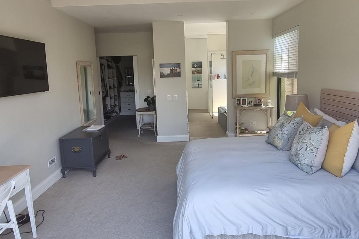 Spacious master bedroom featuring neutral carpeting, recessed lighting, an integrated walk-in closet, and direct access to an en-suite bathroom.