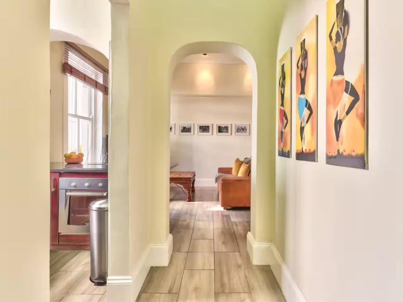 A bright hallway featuring tiled flooring and an elegant archway leading into the living area, creating a seamless flow between spaces.