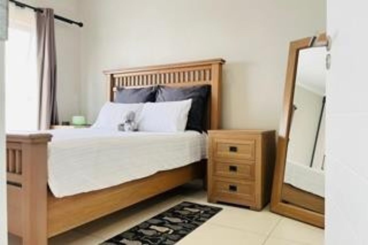 A well-maintained bedroom featuring neutral wall tones and tiled flooring, offering a clean and functional living space.