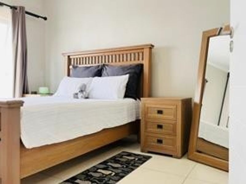A well-maintained bedroom featuring neutral wall tones and tiled flooring, offering a clean and functional living space.