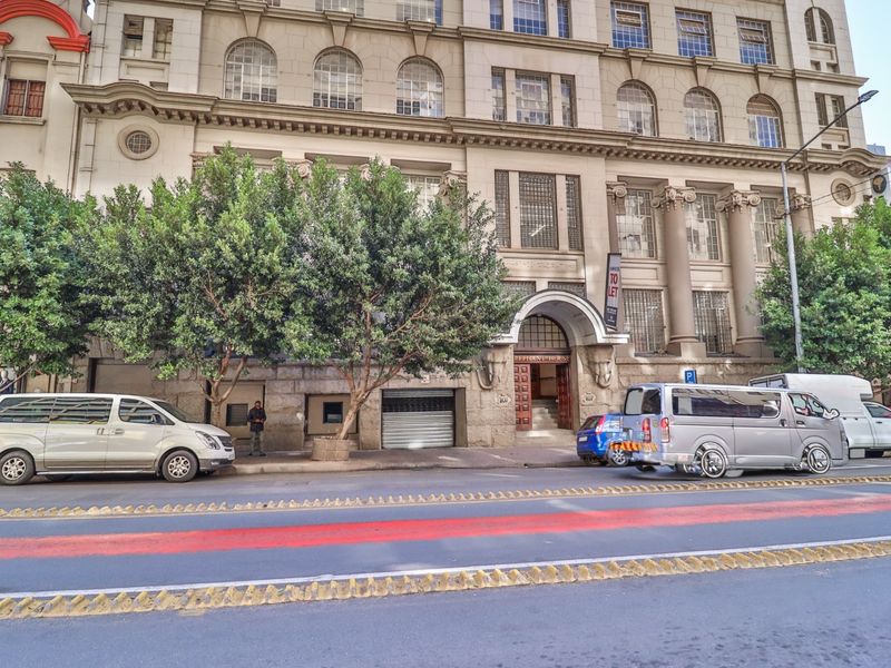 A classic multi-story commercial building facade featuring stone masonry, arched entrance detailing, and traditional architectural columns.