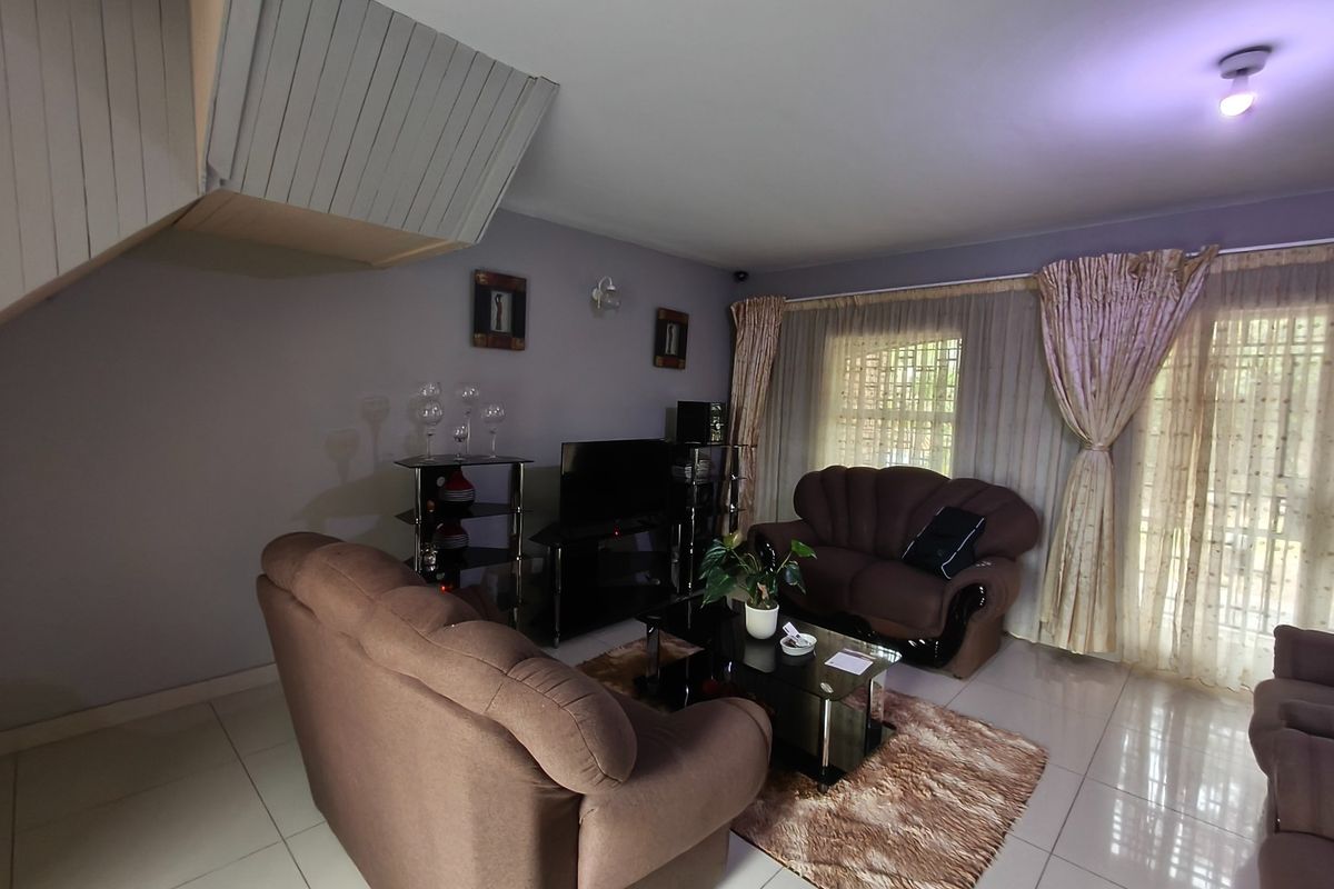 A living room featuring tiled flooring and a staircase bulkhead, providing a functional space for relaxation and entertainment.