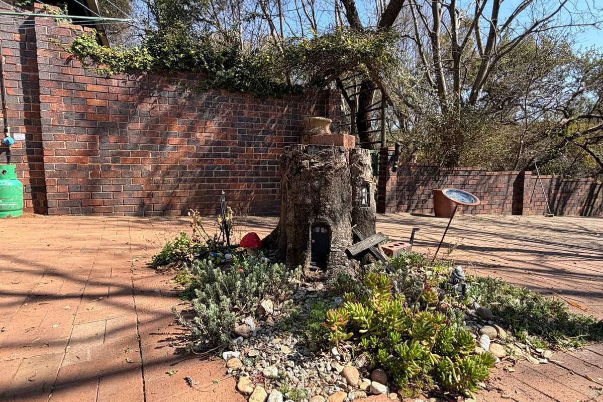 A rear outdoor area featuring brick paving and a solid brick boundary wall, providing a private and enclosed garden space.