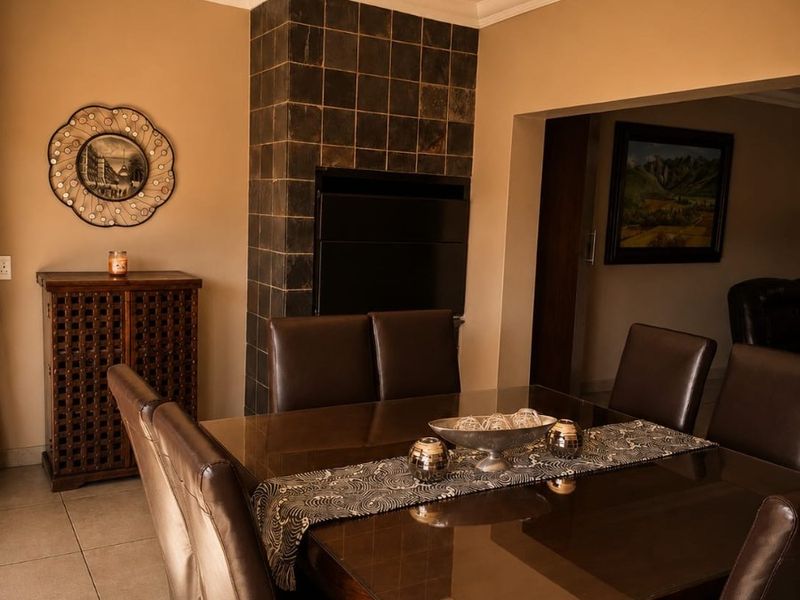 Dining room featuring a built-in fireplace with dark tiled surround, ceramic floor tiles, and decorative ceiling cornice.