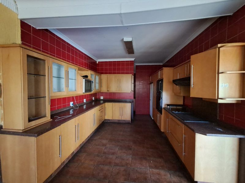 Spacious kitchen featuring extensive built-in cabinetry, granite countertops, and integrated appliances, offering a functional layout ready for modernization.
