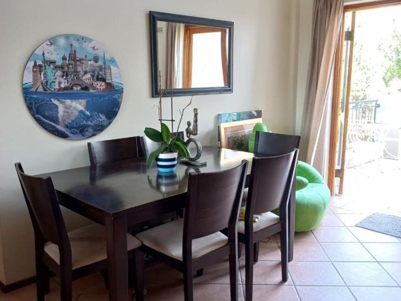 Dining area featuring ceramic tile flooring and direct access to an outdoor patio through a glass-paneled door.