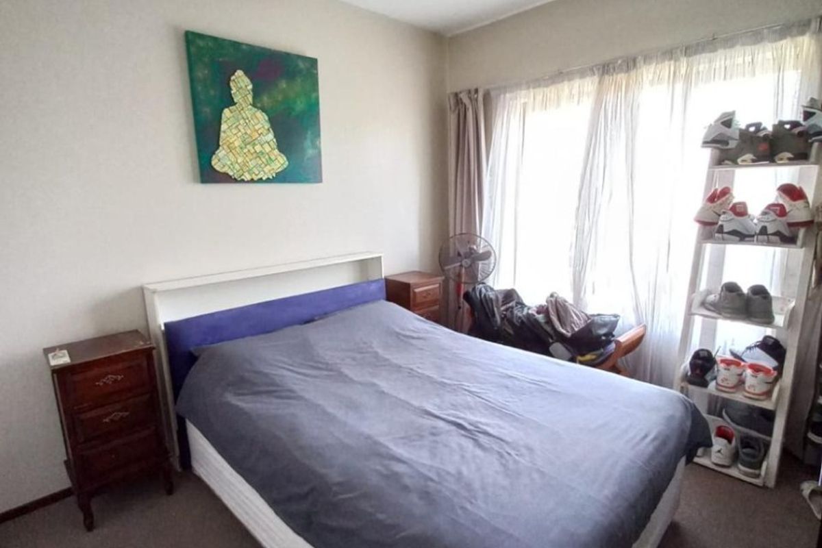 A standard bedroom featuring carpeted flooring and a central ceiling light fixture, offering a functional space with natural light from the window.