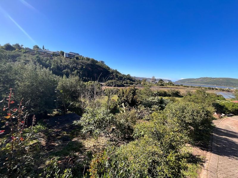 A scenic view overlooking the natural landscape, surrounding hills, and distant water, showcasing the property's tranquil setting and outdoor environment.
