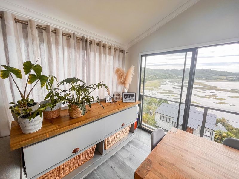 A bright living area featuring tiled flooring, modern sliding glass doors, and expansive views of the surrounding landscape.