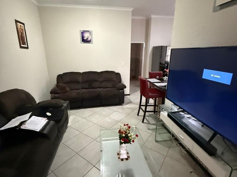Open plan living and dining area featuring tiled flooring and coved ceilings, providing a functional space for relaxation and meals.