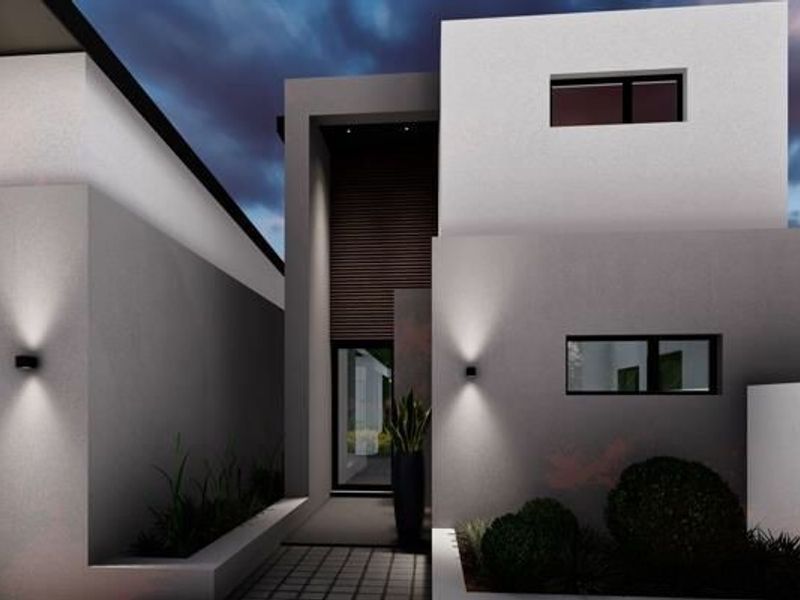 A modern two-story residential facade featuring clean architectural lines, recessed entrance, integrated wall lighting, and landscaped garden beds.