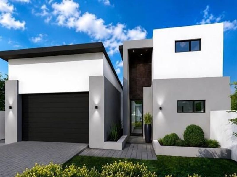Modern two-story residential facade featuring a sleek garage, clean architectural lines, and a well-maintained front garden entrance.