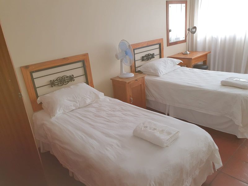 A functional bedroom featuring tiled flooring and neutral wall finishes, suitable for a guest room or secondary bedroom.