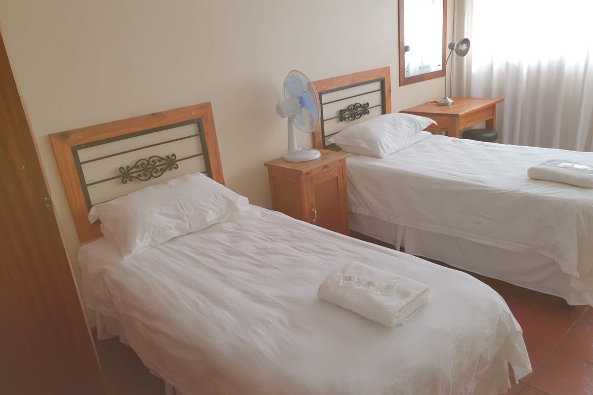 A functional bedroom featuring tiled flooring and neutral wall finishes, suitable for a guest room or secondary bedroom.
