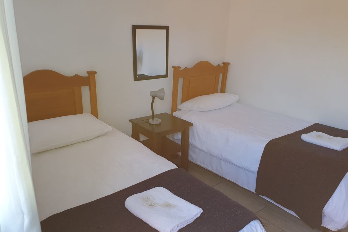 A simple bedroom featuring tiled flooring and neutral wall finishes, suitable for a guest room or children's bedroom.