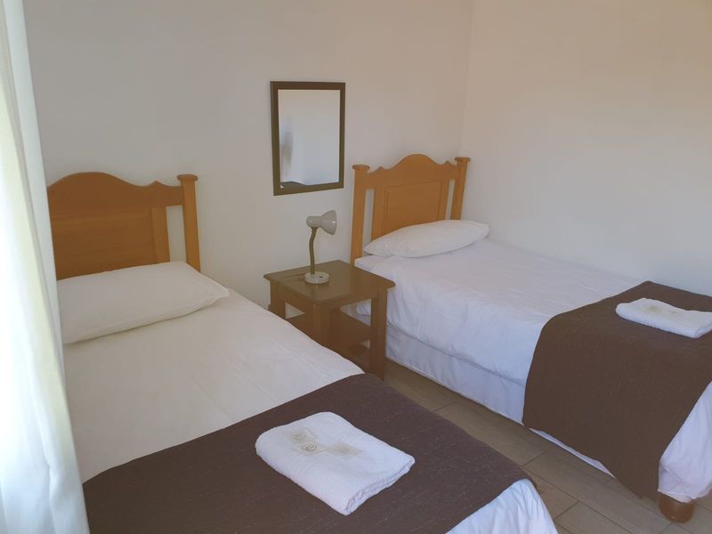 A simple bedroom featuring tiled flooring and neutral wall finishes, suitable for a guest room or children's bedroom.