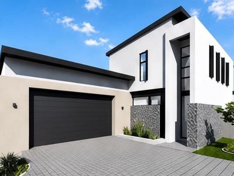 Modern double-storey home featuring a sleek facade with stone cladding, a paved driveway, and a spacious double garage.