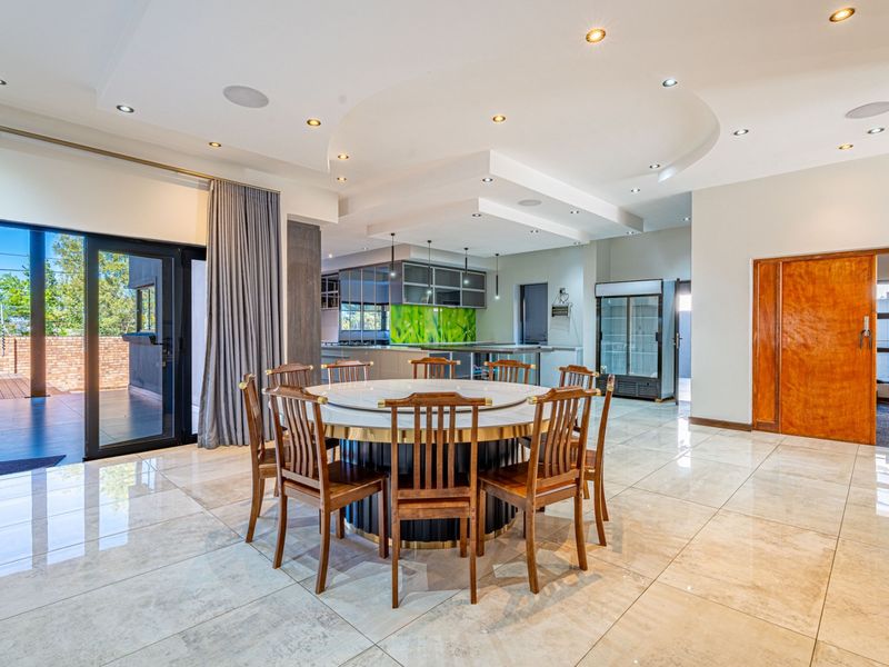 Spacious open-plan living and dining area featuring polished tile flooring, recessed ceiling lighting, and seamless access to an outdoor patio through sliding glass doors.