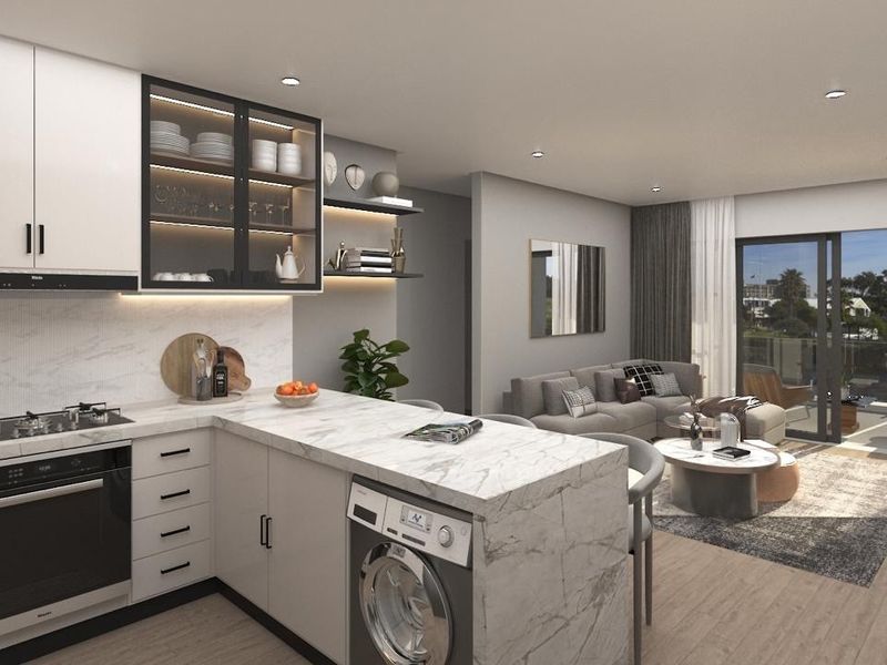 Modern open-plan kitchen and living area featuring high-end finishes, integrated appliances, marble-look countertops, and seamless access to a private balcony.
