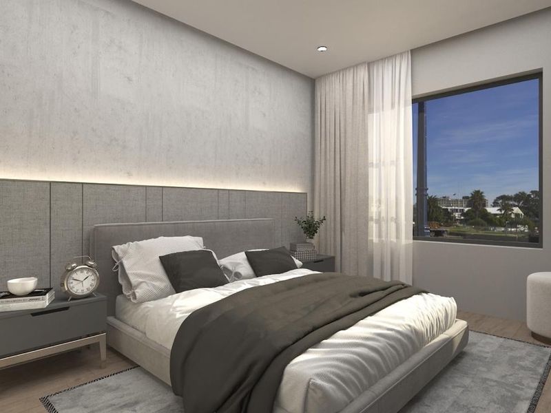 A modern, well-lit bedroom featuring integrated headboard wall paneling with ambient LED accent lighting and a large window with exterior views.