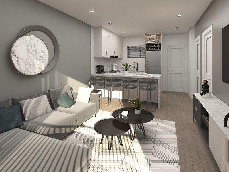 Modern open-plan living area featuring a sleek kitchen with stone countertops, integrated cabinetry, and recessed lighting, seamlessly flowing into the lounge space.