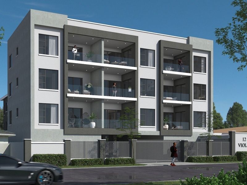 A modern multi-story apartment building featuring glass-fronted balconies, secure perimeter fencing, and a gated entrance.