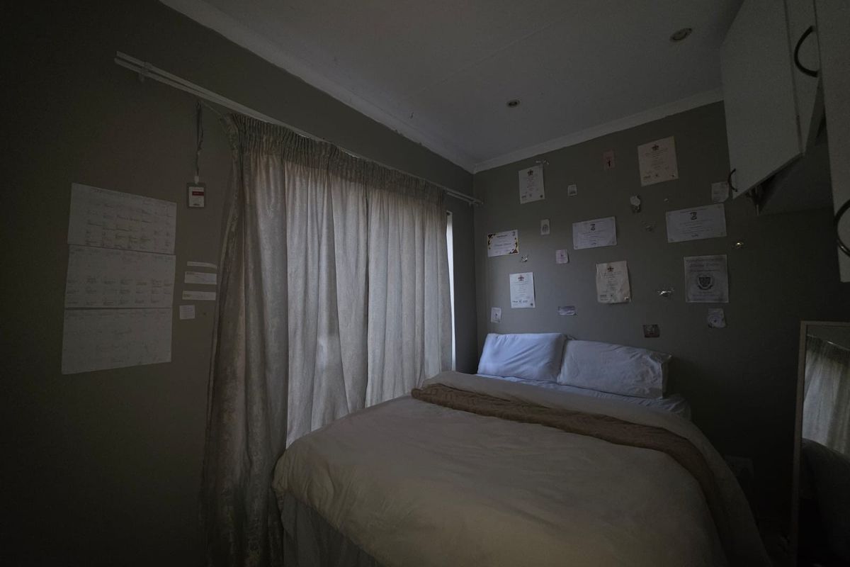 A compact bedroom featuring recessed downlighting, built-in cabinetry, and a window dressed with curtains.