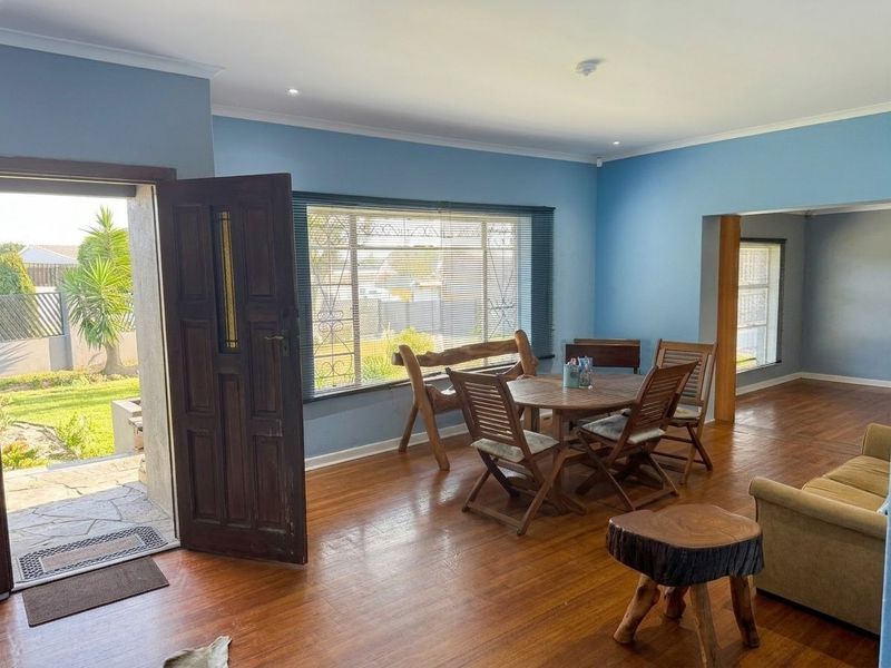 Spacious living area featuring hardwood flooring, recessed lighting, and direct access to the garden through a secure entrance door.