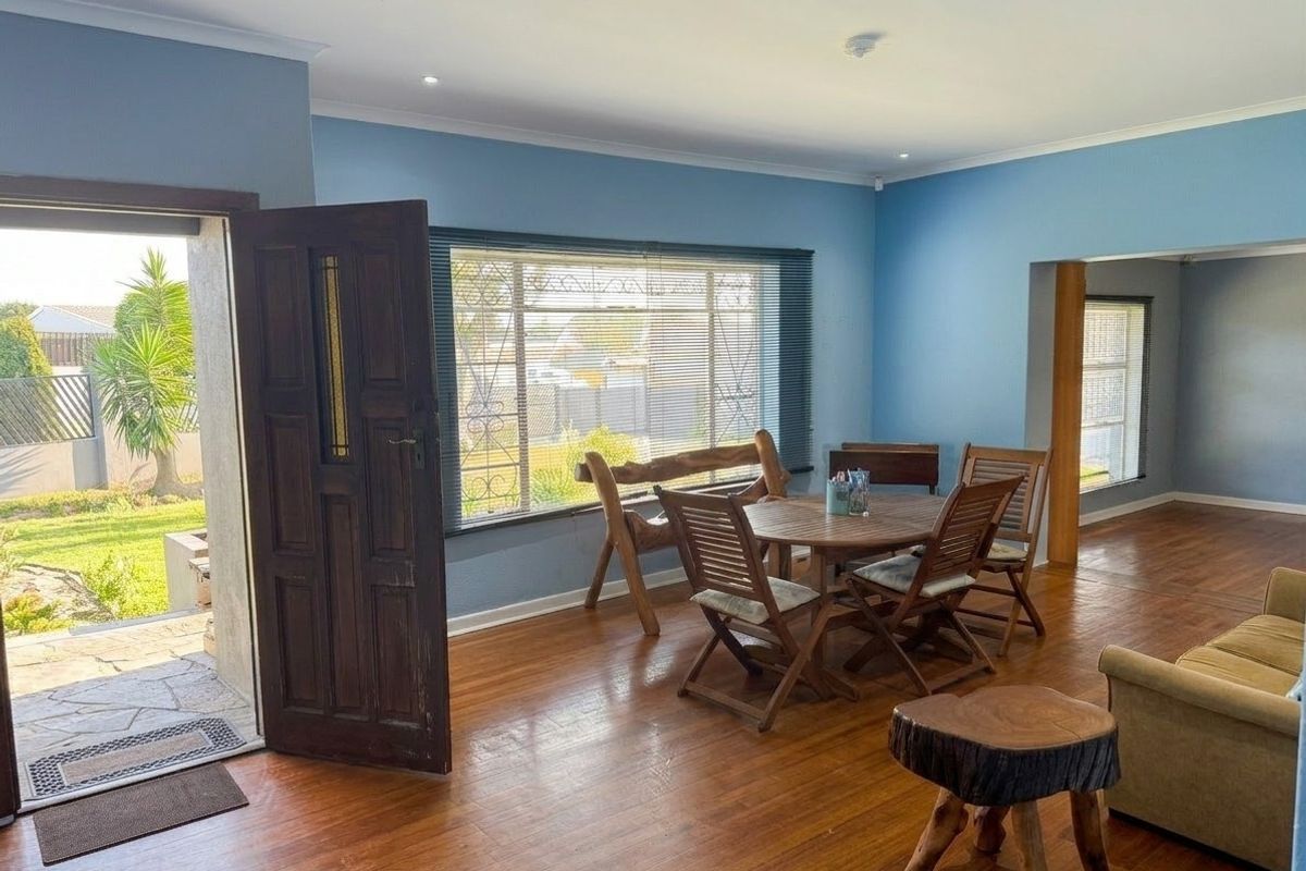 Spacious living area featuring hardwood flooring, recessed lighting, and direct access to the garden through a secure entrance door.