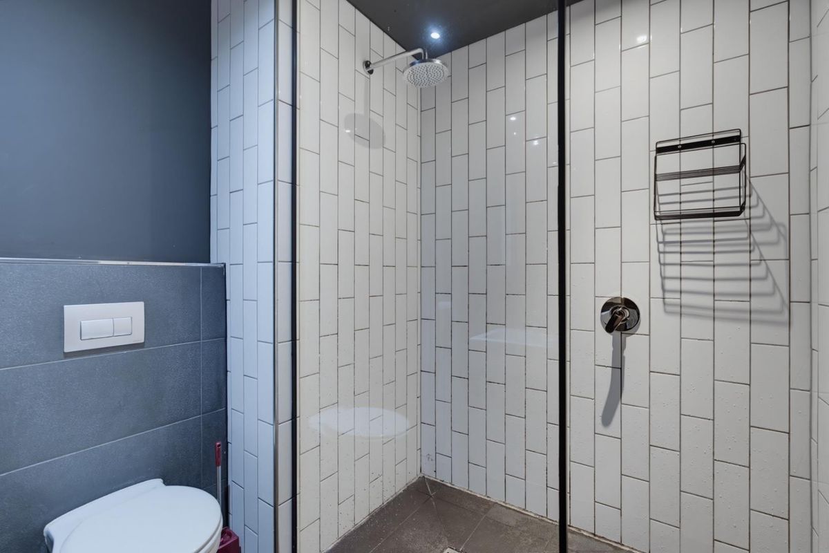 Modern bathroom featuring a walk-in shower with subway tiling, glass screen, and a wall-mounted toilet with contemporary finishes.