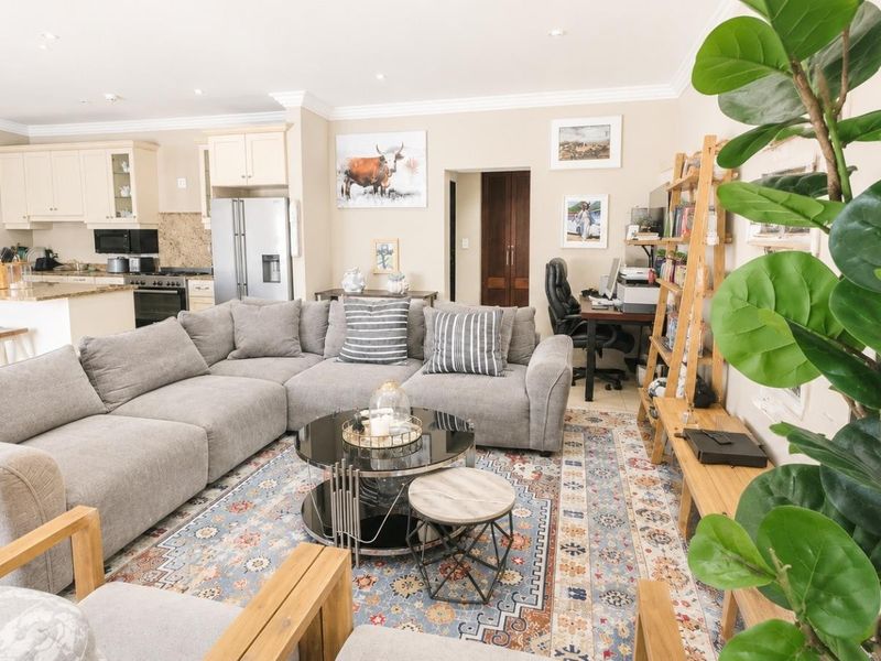 Spacious open-plan living area featuring a well-appointed kitchen with granite countertops, recessed lighting, and seamless flow into the comfortable lounge and study nook.
