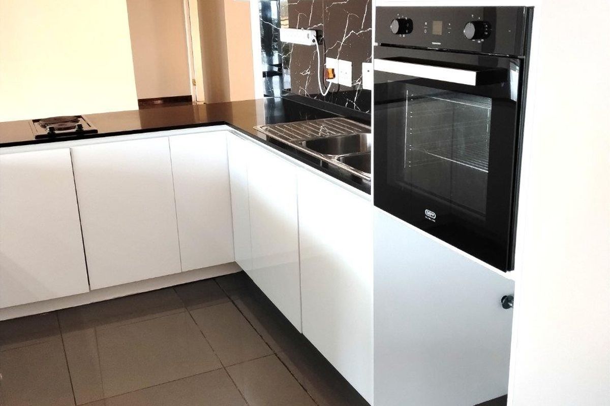 Modern kitchen featuring white cabinetry, black marble-look splashback, built-in oven, hob, and sleek tiled flooring in an open-plan layout.