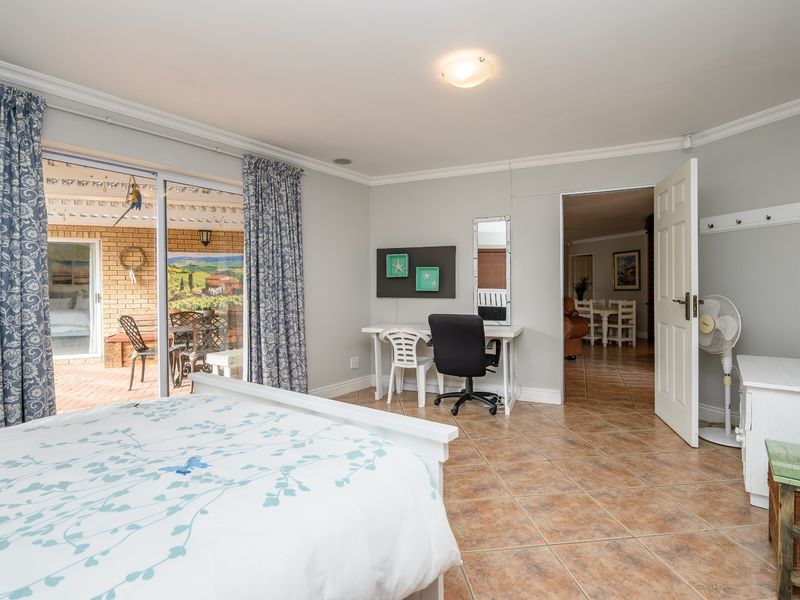 Spacious bedroom featuring ceramic tile flooring, crown molding, and a large sliding glass door providing direct access to the outdoor patio area.