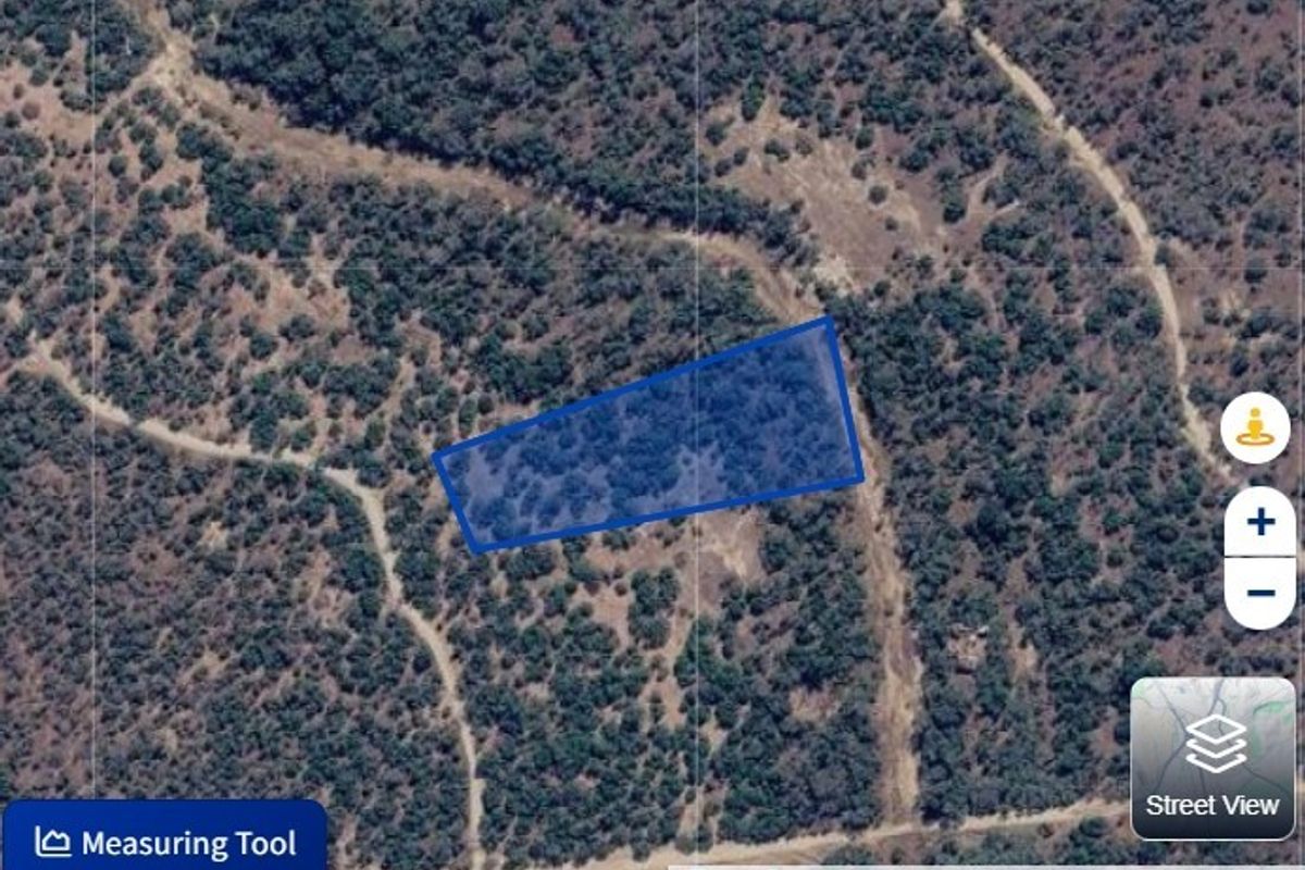 An aerial satellite view showing the property boundary and surrounding natural landscape.