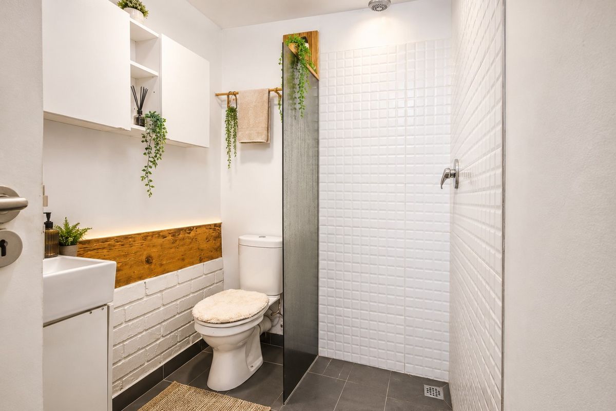 Modern bathroom featuring a walk-in shower with white mosaic tiling, a wall-mounted vanity, and built-in storage cabinetry.