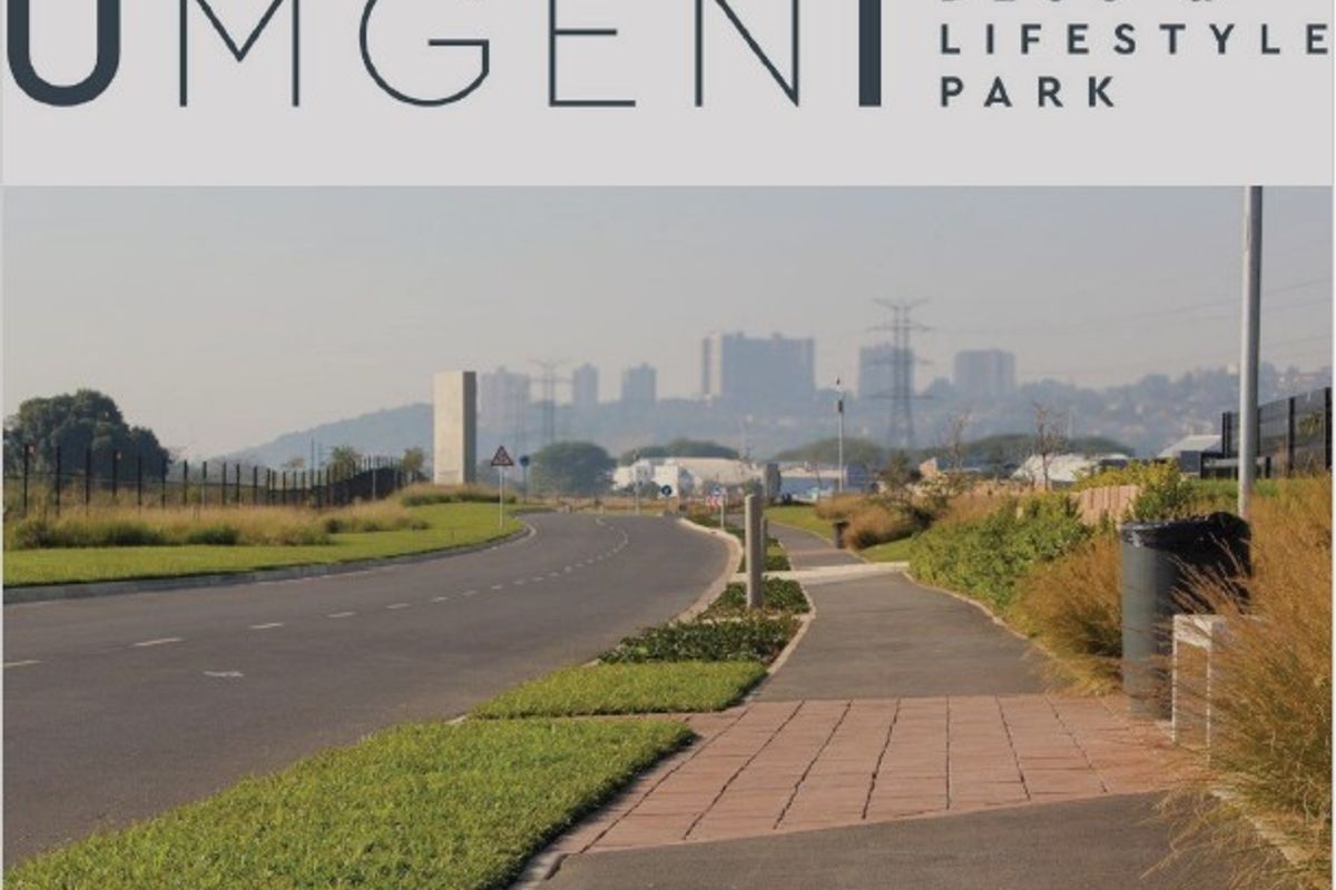 Street view of the Umgeni Deco & Lifestyle Park, featuring paved walkways, landscaped verges, and asphalt road access.