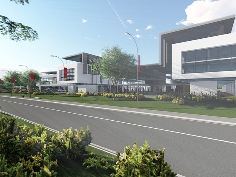 A professional architectural rendering of a modern retail and commercial complex viewed from the street, showcasing contemporary building design and landscaped surroundings.
