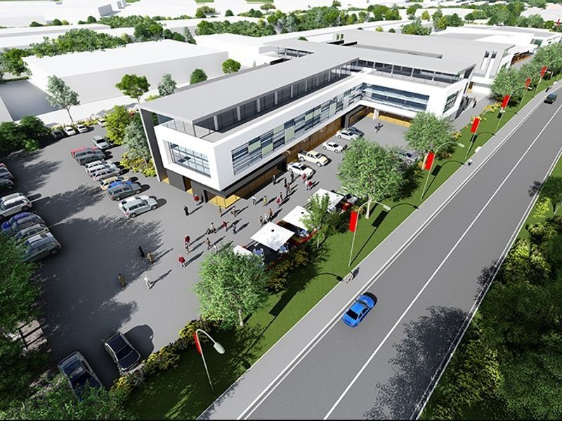 Aerial perspective of a modern commercial retail complex featuring extensive parking facilities and integrated pedestrian access areas.