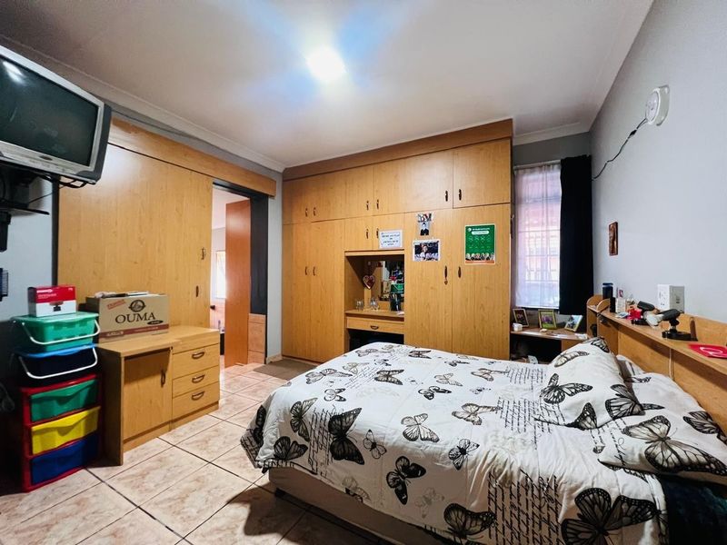 A bedroom featuring extensive built-in wooden cabinetry, a built-in vanity, and tiled flooring.