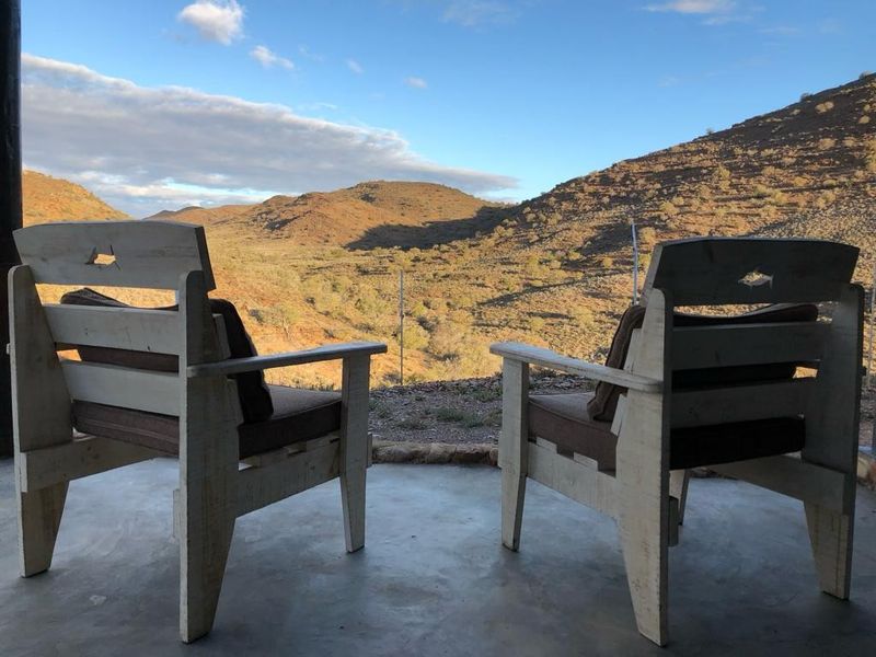 A scenic outdoor view from a concrete patio overlooking a rugged mountain landscape.