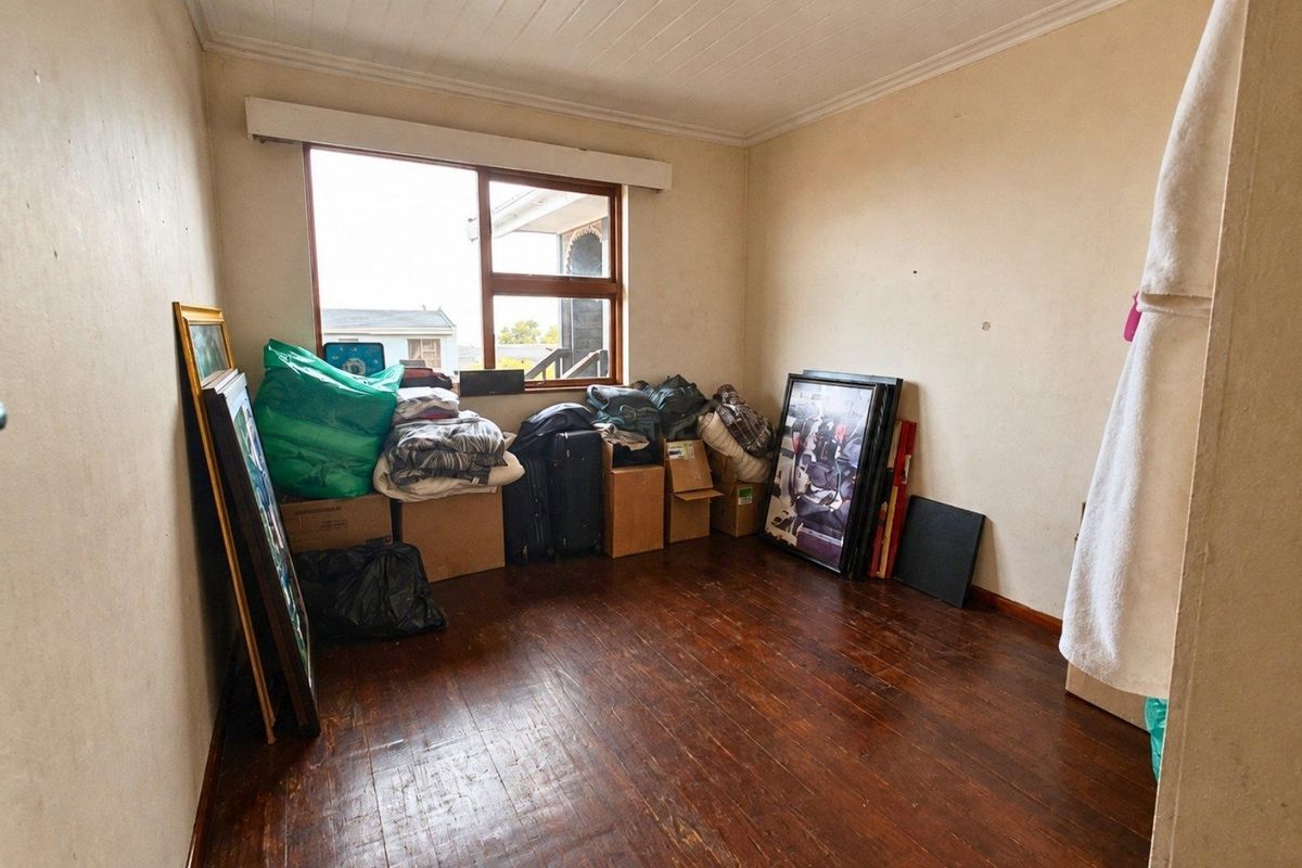 A bedroom featuring original timber flooring and a tongue and groove ceiling, offering a blank canvas for renovation and interior design updates.