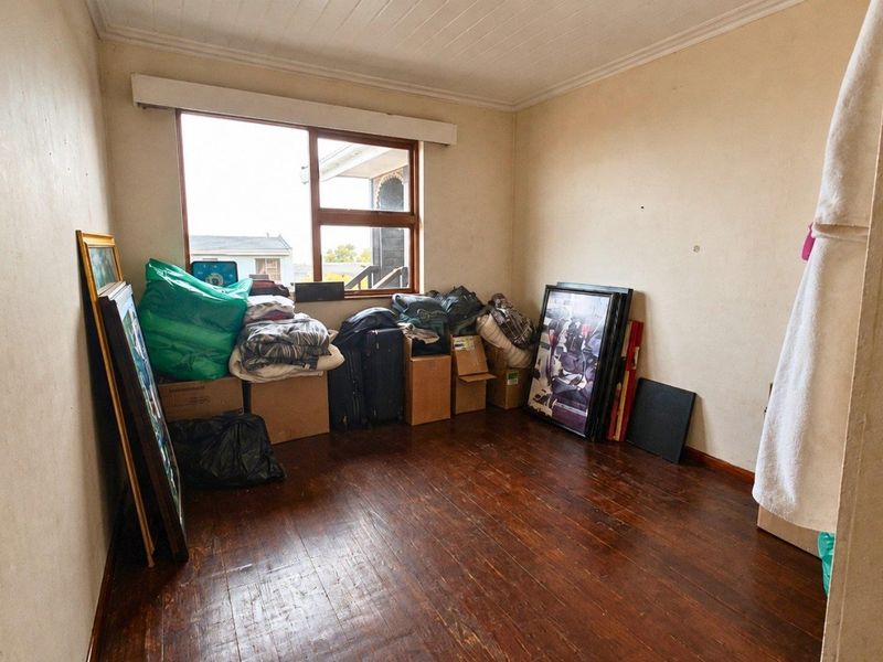 A bedroom featuring original timber flooring and a tongue and groove ceiling, offering a blank canvas for renovation and interior design updates.